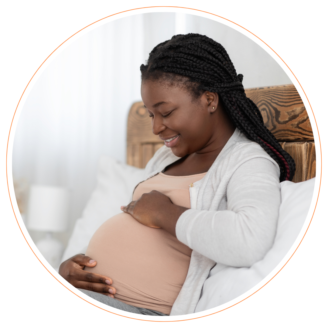 Pregnant-woman-bump Pregnant woman holding bump on bed